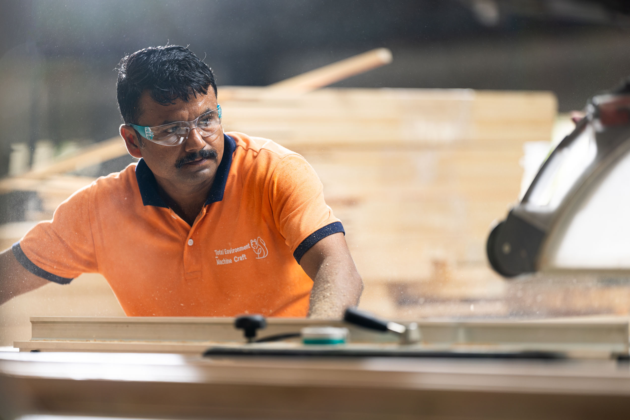 Craftsman with safety goggles working with wood at Machine Craft